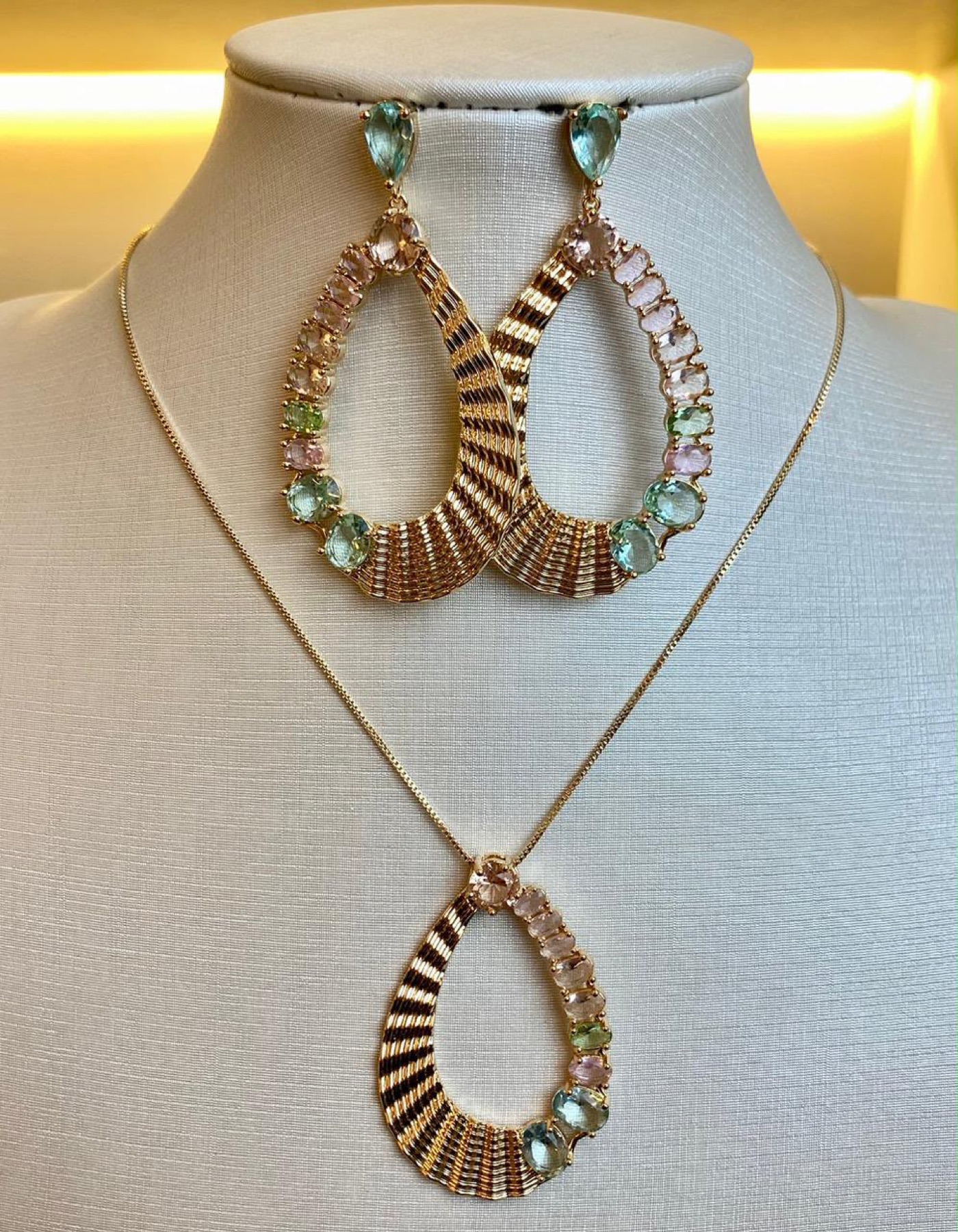 Conjunto dourado com pedras em tons pastel