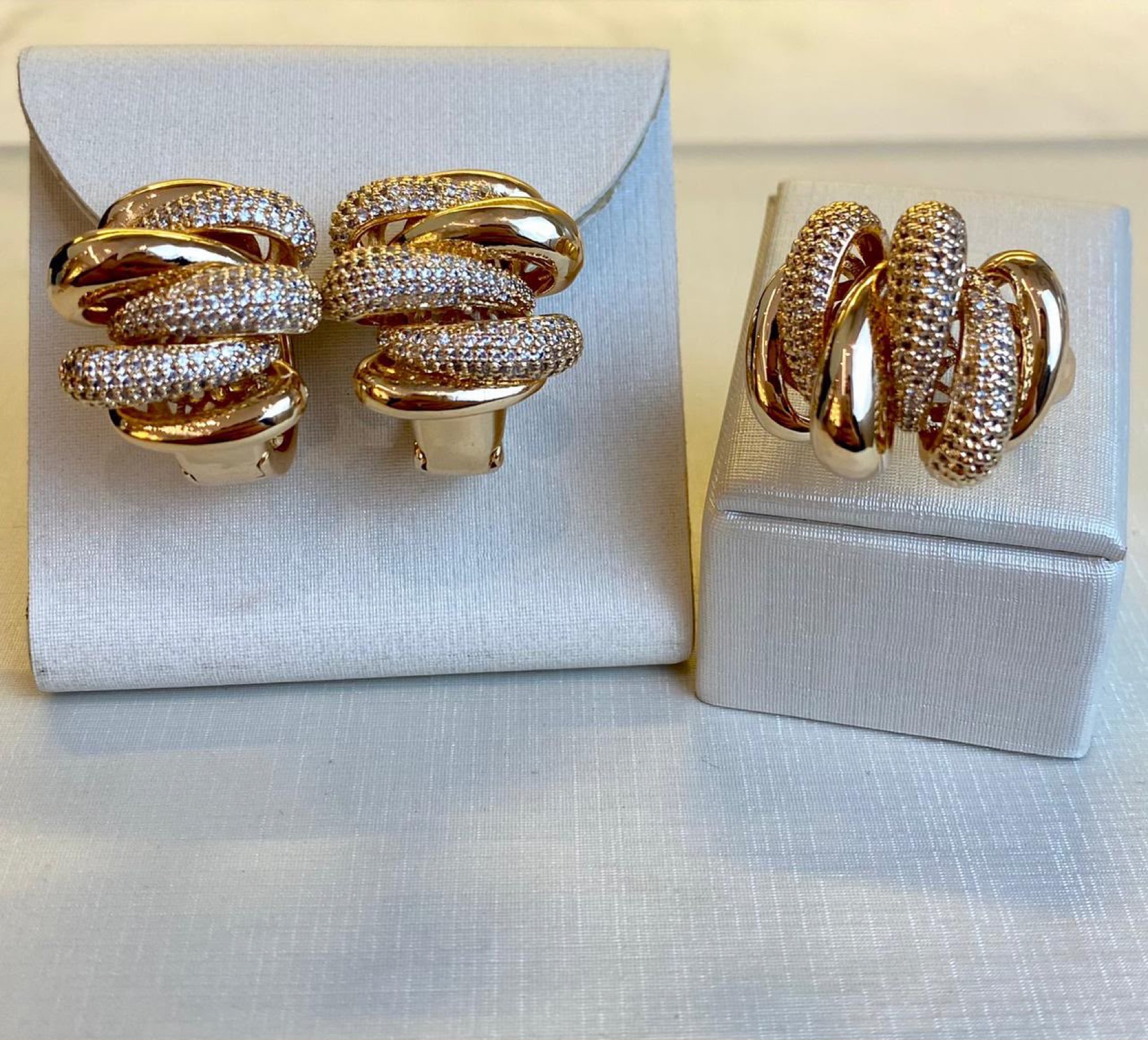 Brincos e anel dourados com detalhes brilhantes